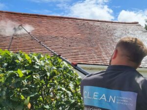 A CLEAN CSS technician softwashing a residential roof